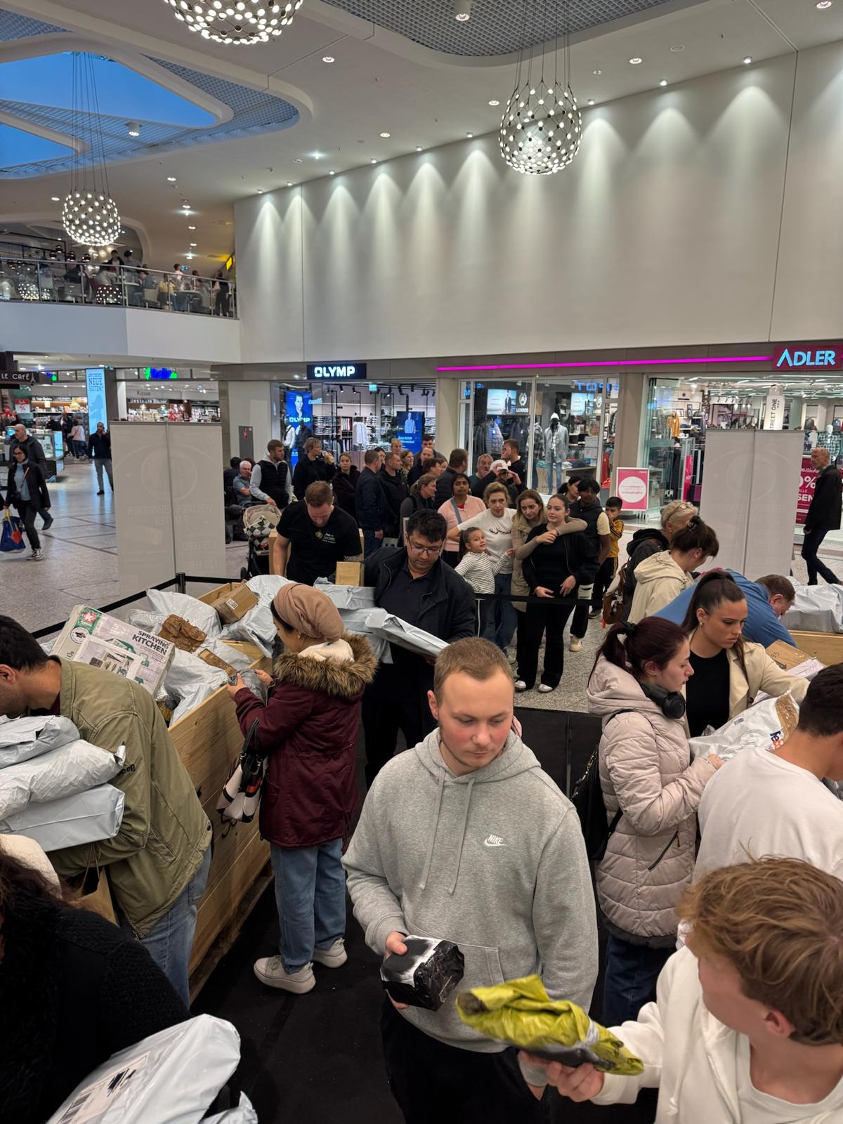 Viele Besucherinnen und Besucher stöbern zwischen den Paketkisten am Hall-of-Secrets-Stand, weitere Menschen warten dahinter.